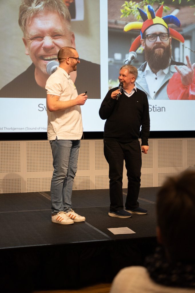 To menn står på scene og smiler til hverandre. Foto: Alexandra Dahlen.