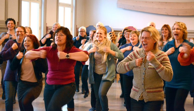 Mange personer står i et stort rom og danser. Foto: Ole Tolstad