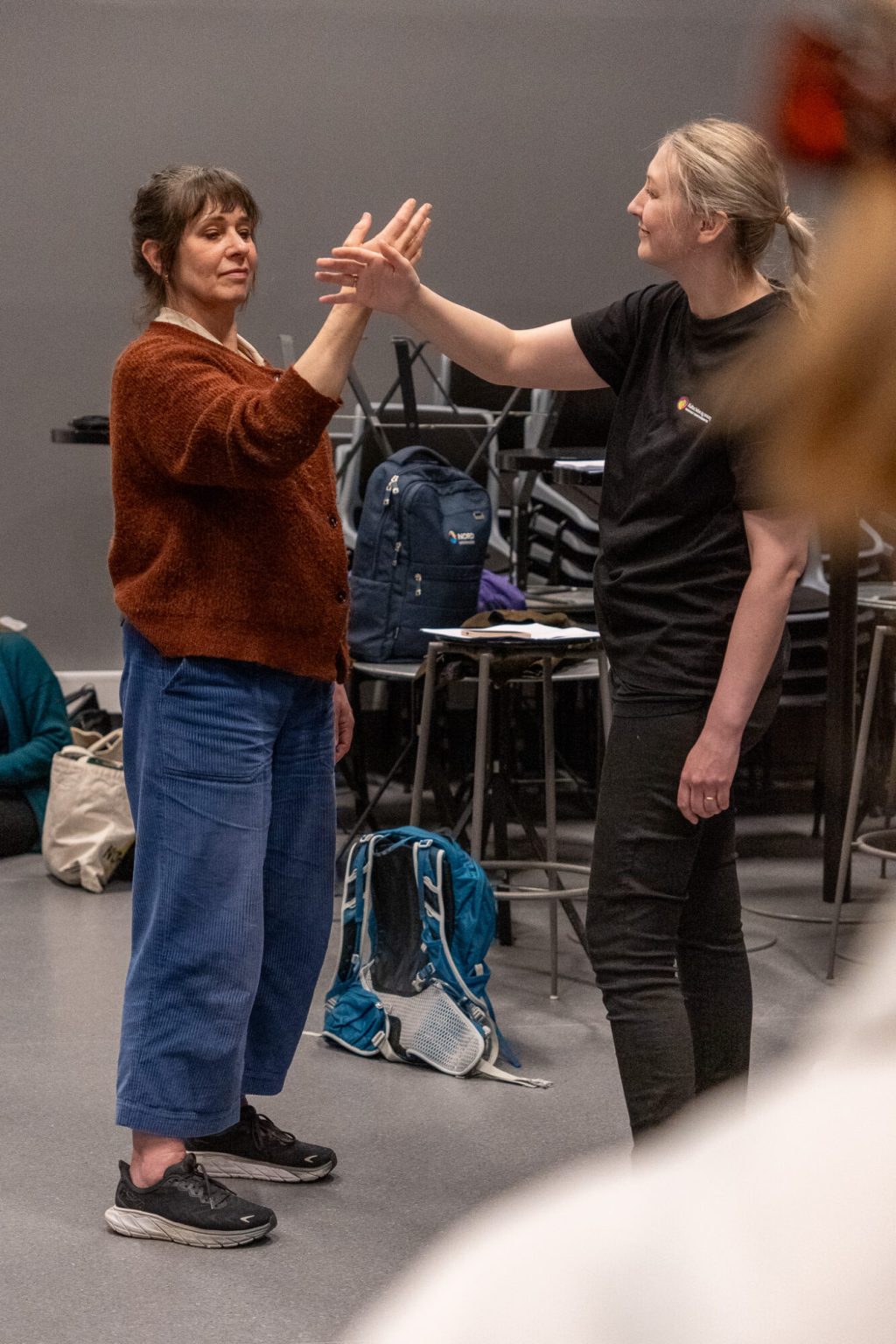 Anna Nordanstedt og Charlotte Stav står mot hverandre. De har begge høyre hånd i luften og hendene berører hverandre. Foto: Alexandra Dahlen.