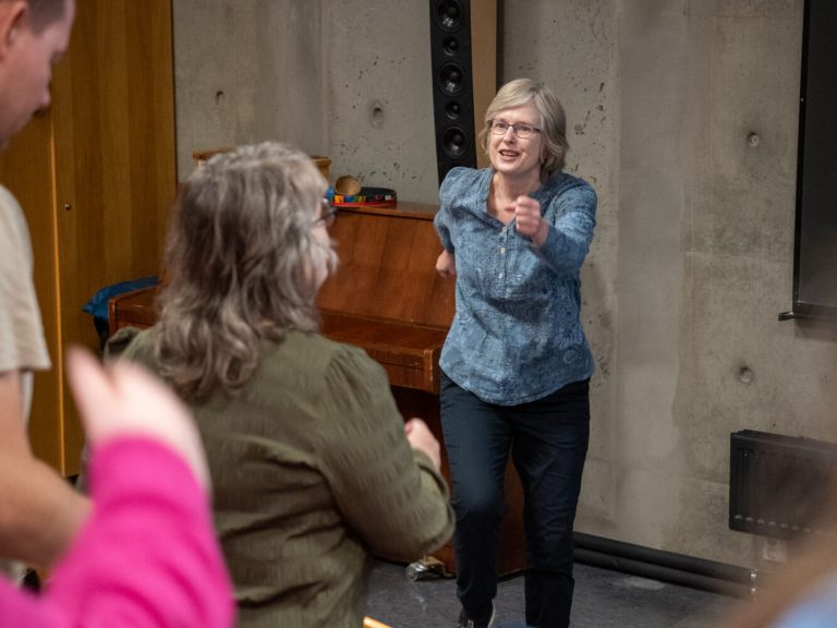 Helene Waage har lyst, skulderlangt hår, briller og en blå bluse. Hun masjerer i et klasserom. Foto: Alexandra Dahlen.