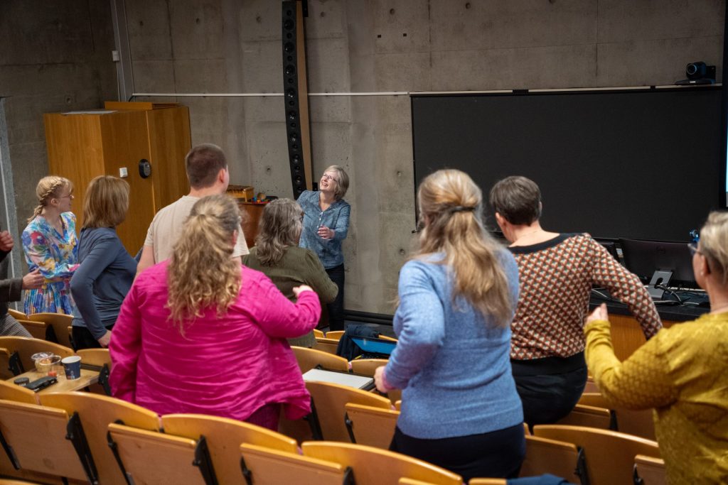 Helene Waage står foran i et auditorium og underviser i trim og trall. Foto.