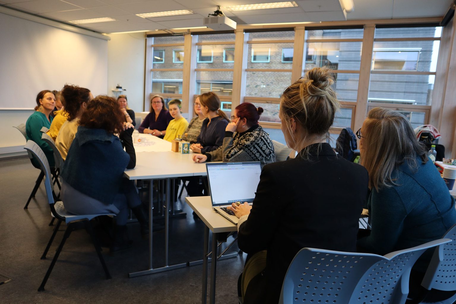 Studentene ved videreutdanningen "Kunst og kultur i helse og omsorg" sitter sammen rundt et bord. På enden sitter to sensorer. Foto: Marit Stranden.