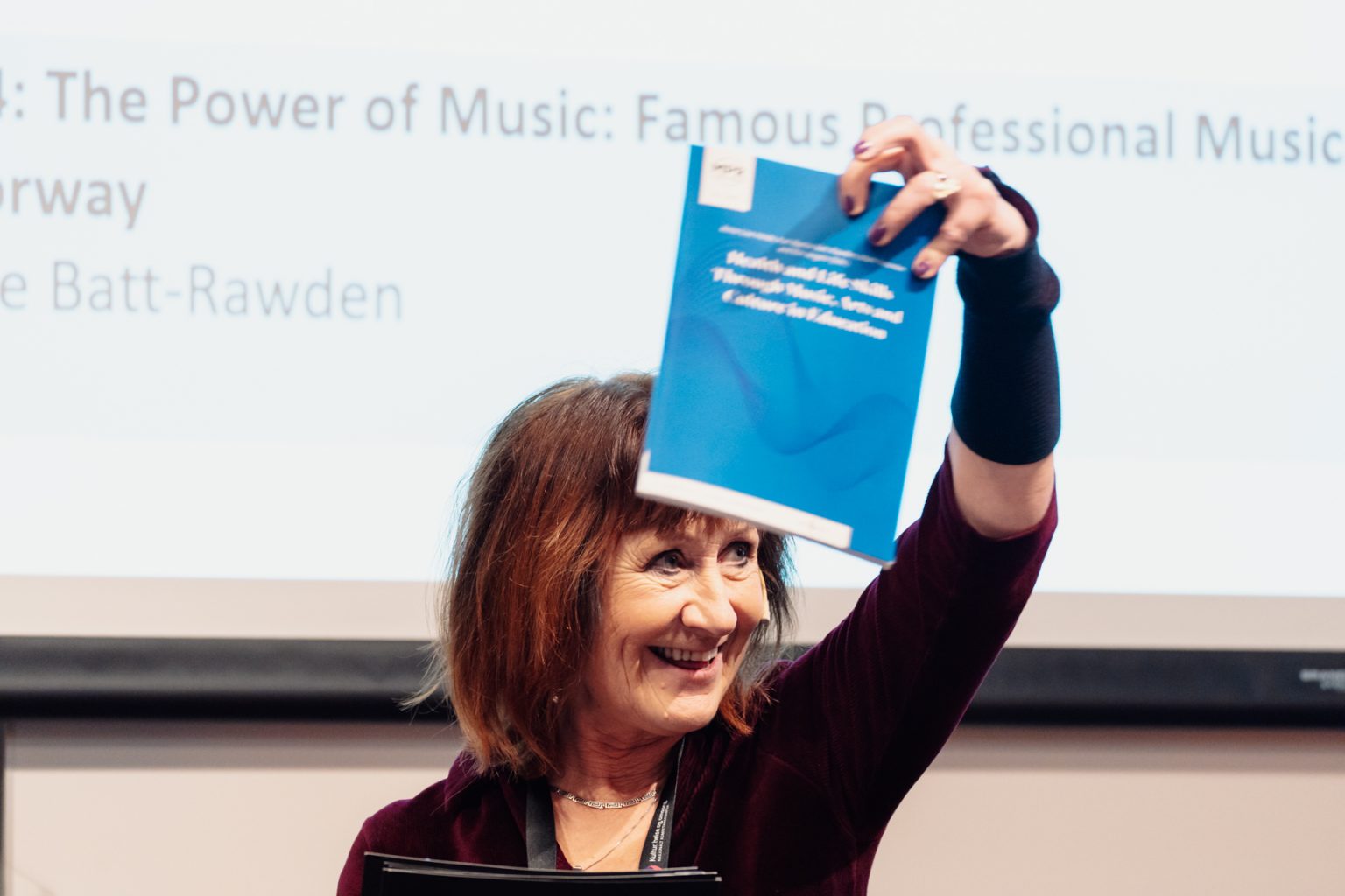 Anne Lise-Heide viser frem boka "Health and Life Skills Through Music, Arts and Culture in Education". Foto: Christian Trustrup, TA-Kreativ.