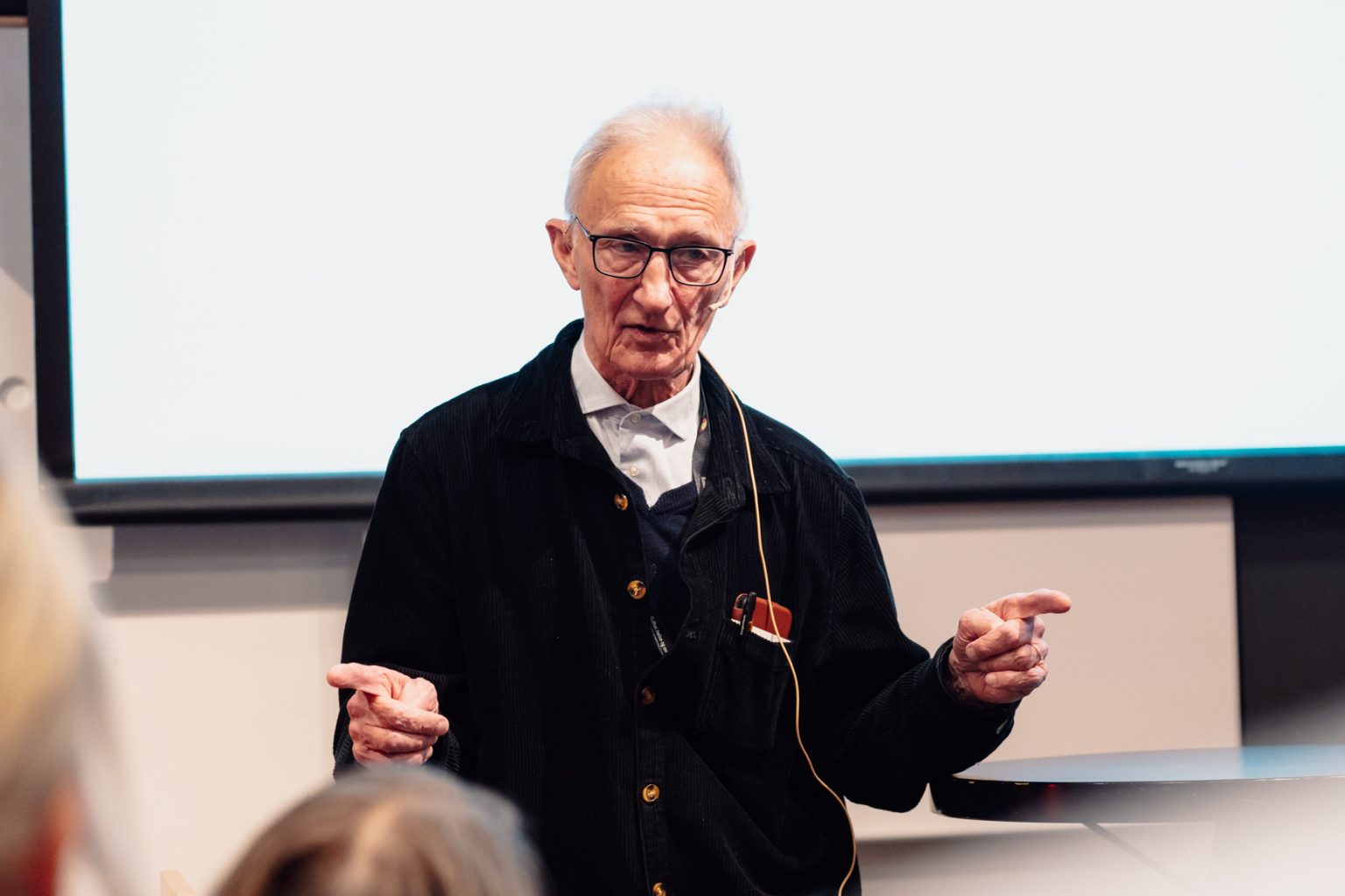 Töres Theorell holder foredrag. Han har kort, grått hår og briller. Han har på seg en lys skjorte og en mørk jakke over. Foto: Christian Trustrup, TA-Kreativ.