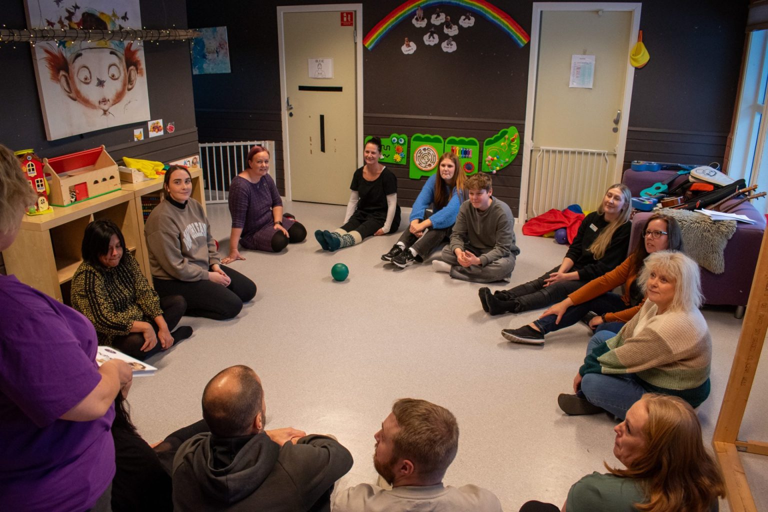 Voksne personer sitter i en sirkel på gulvet. Foto: Gonzalo Sentana.