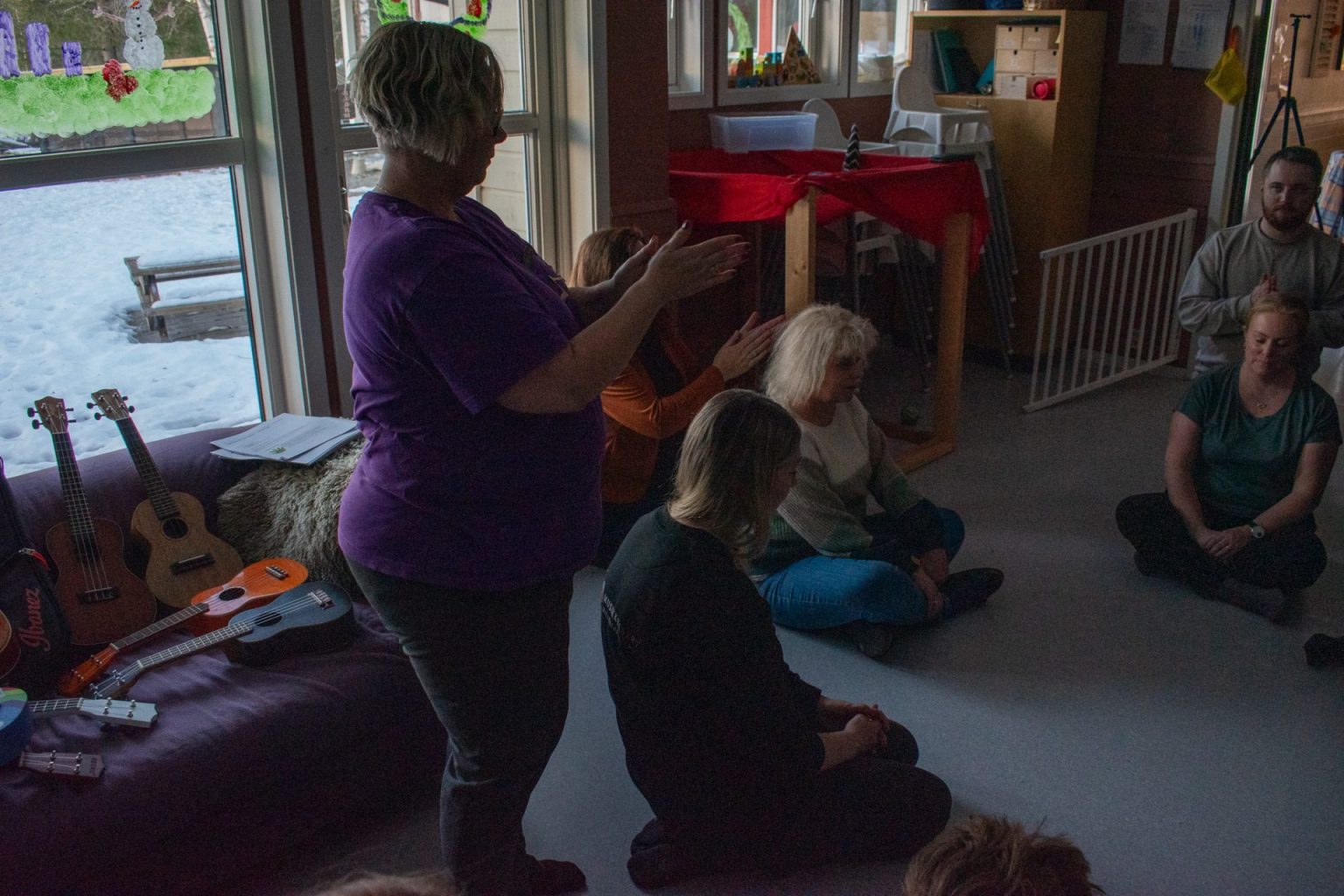 Camilla Stafne står og gnir hendene mot hverandre. Foran henne sitter flere personer i en sirkel. Foto: Gonzalo Sentana.