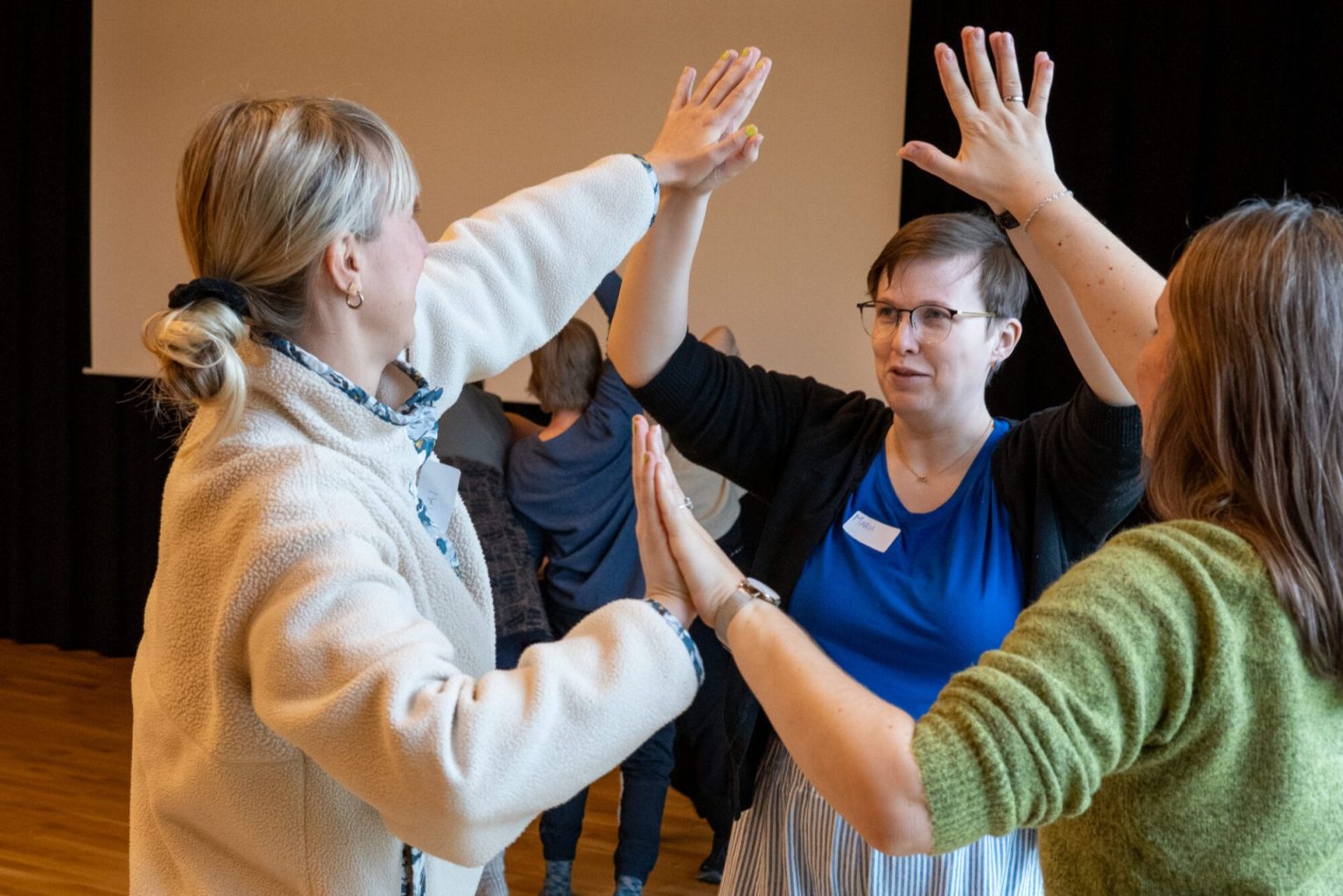 Tre kvinner danser sammen. Foto.