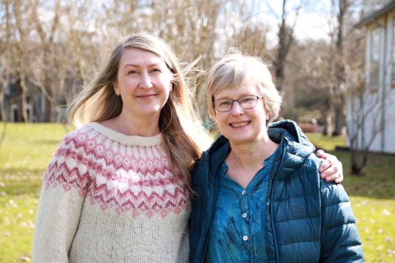 Charlotte Stav og Helene Waage står ved siden av hverandre og smiler til kamera. Foto.