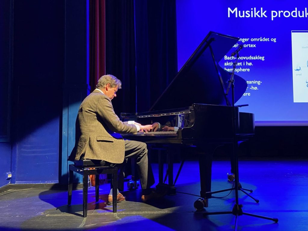 Geir Olve Skeie spiller piano på en scene. Foto.