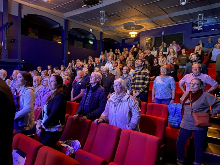 Publikum står i en kinosal. Foto.