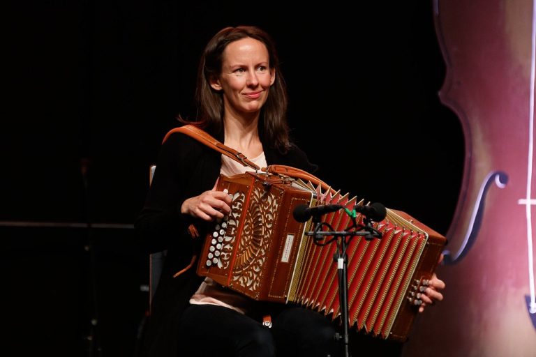 Ragnhild Bjærtnes sitter på en stol og spiller torader. Foto.