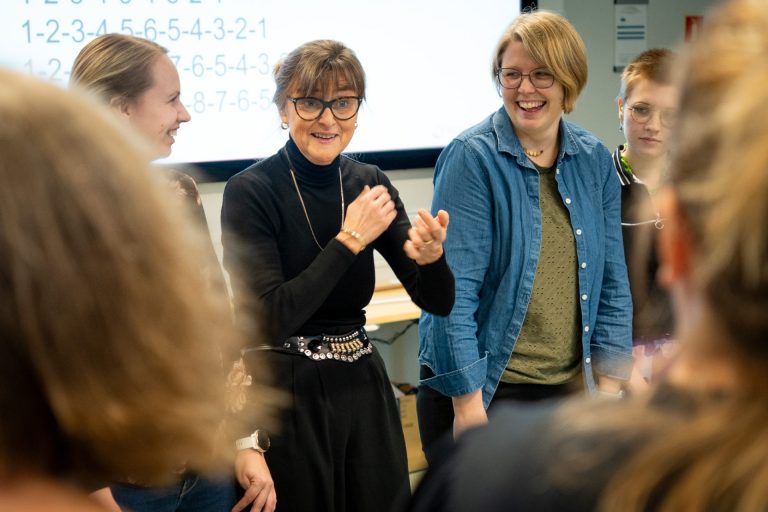 Ragnhild Skulle står sammen med studenter på videreutdanningen i musikkbasert miljøbehandling. Foto.