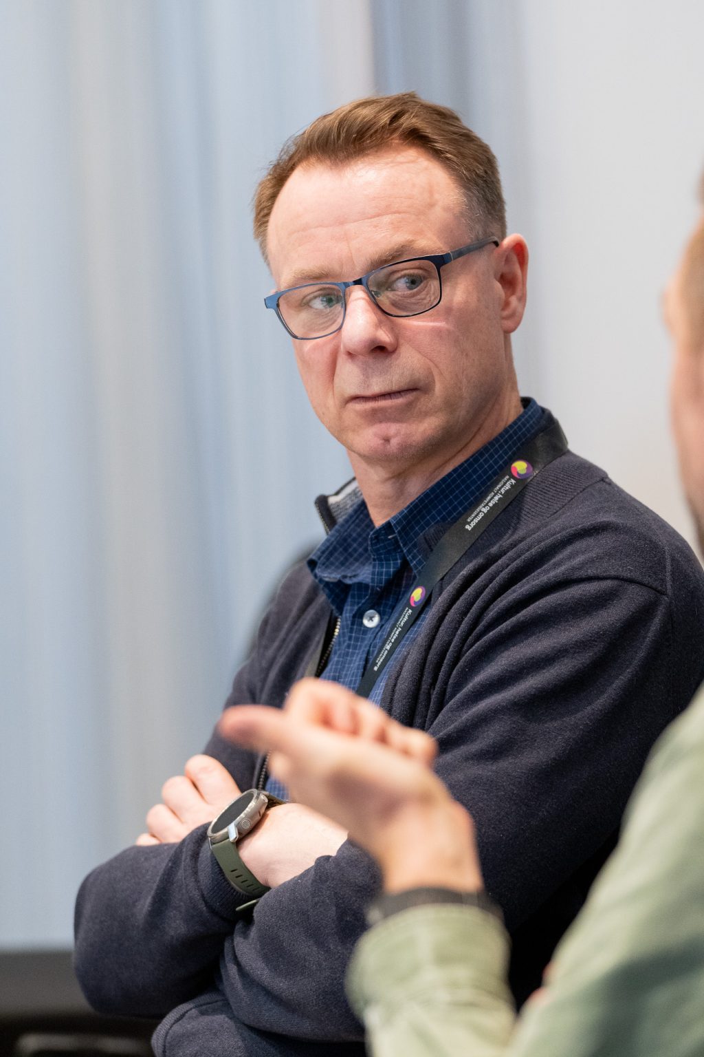 En mann sitter og lytter til en annen person.