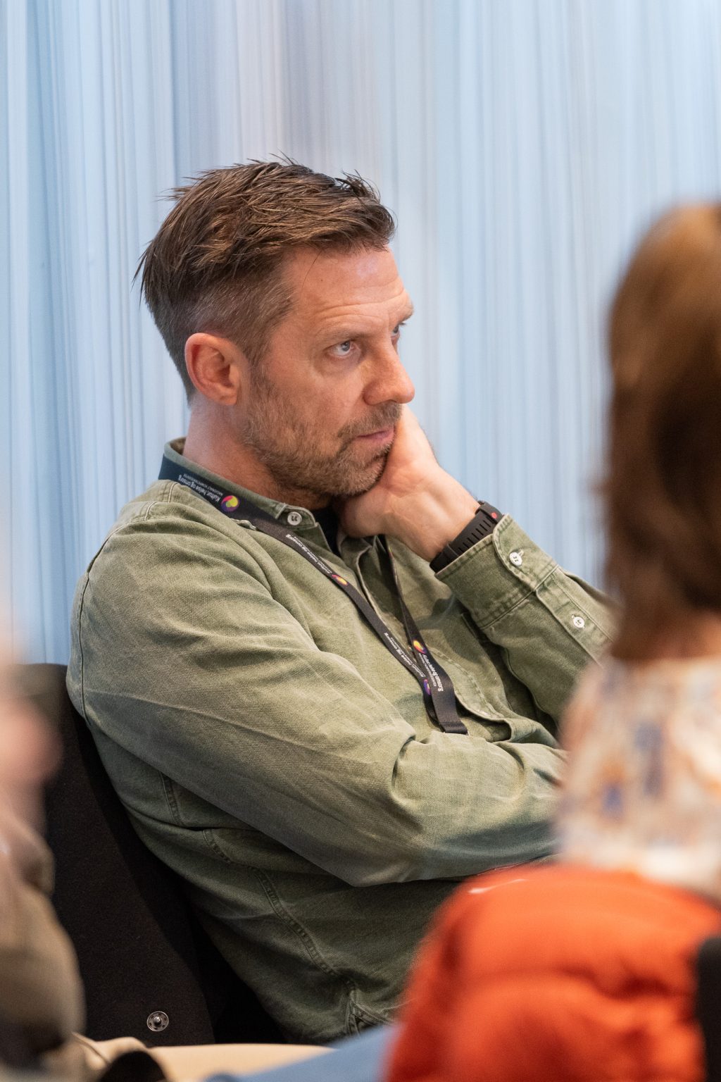 En mann sitter og lytter til et foredrag.