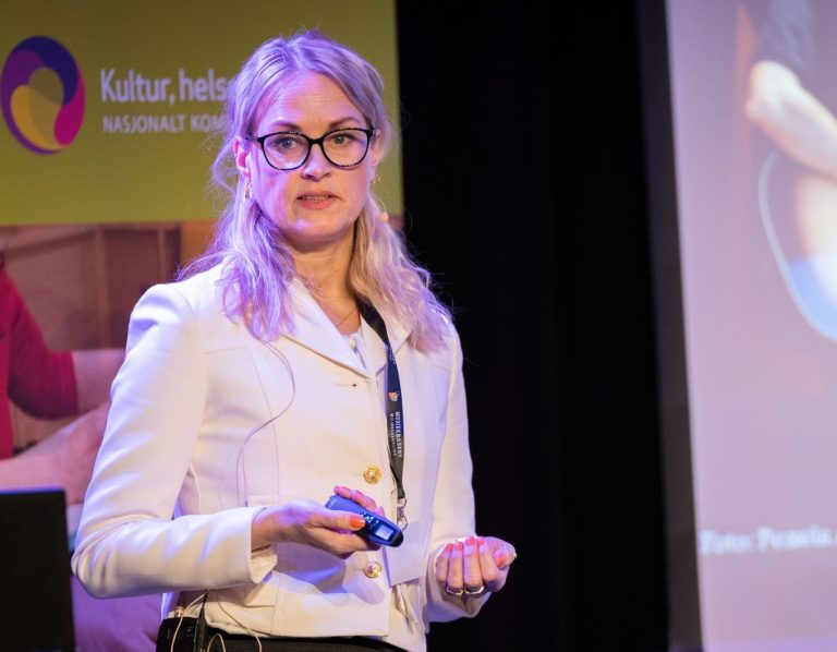 Ingrid S. Følling holder foredrag fra scenen.
