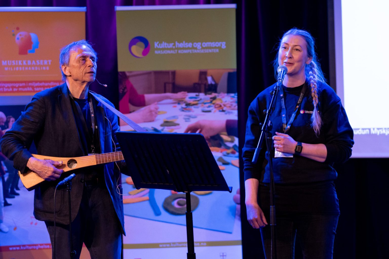 Audun Myskja og Charlotte Stav står på scenen og synger.