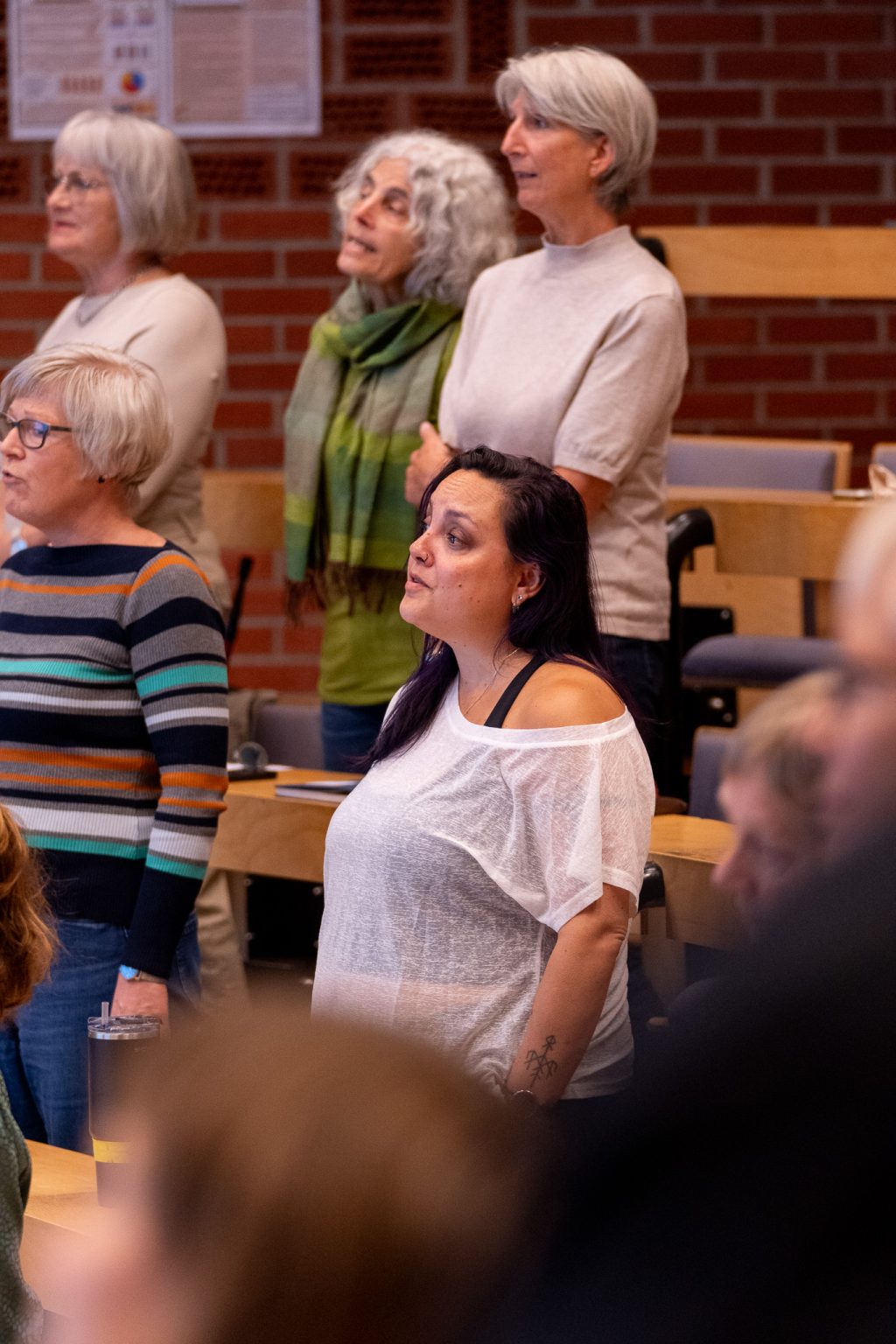 Publikum står i et auditorium og synger.