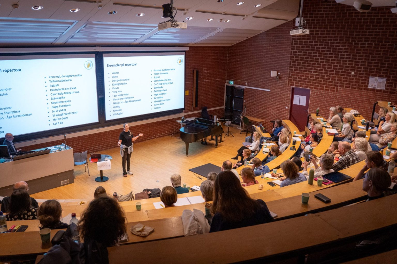 Charlotte Stav holder foredrag i et auditorium.