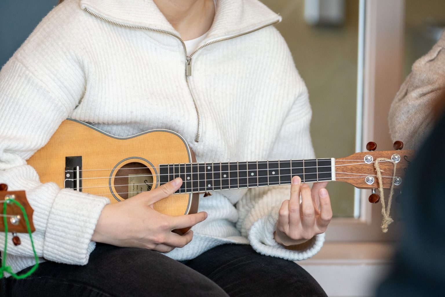 En kvinne spiller ukulele.