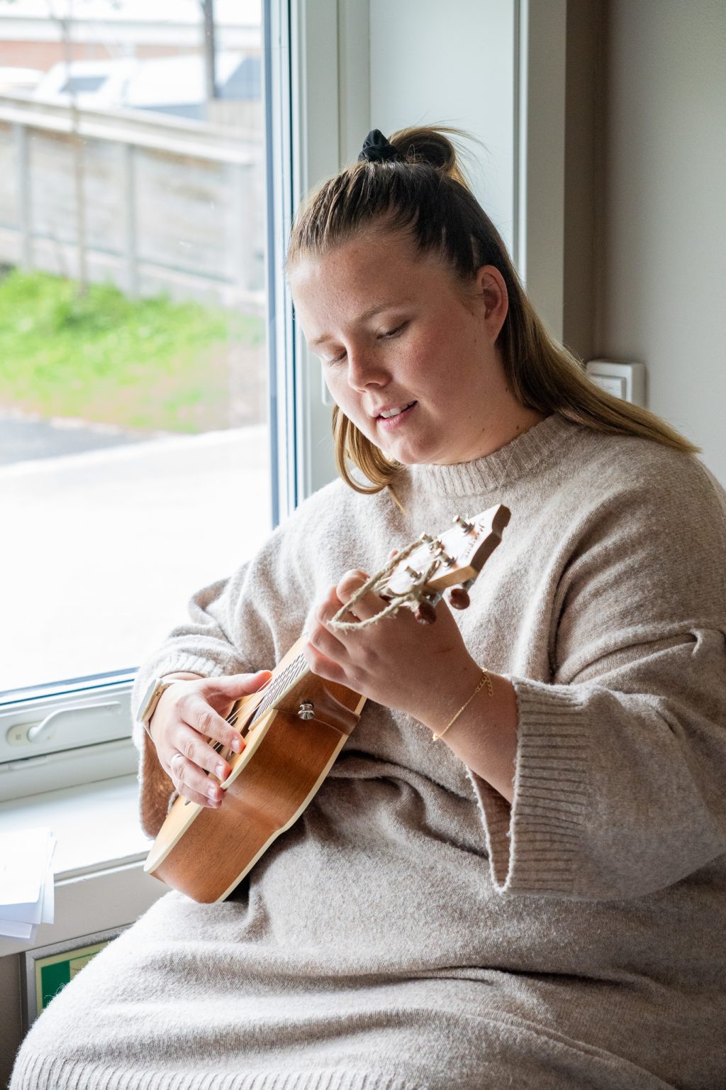 En kvinne spiller ukulele.