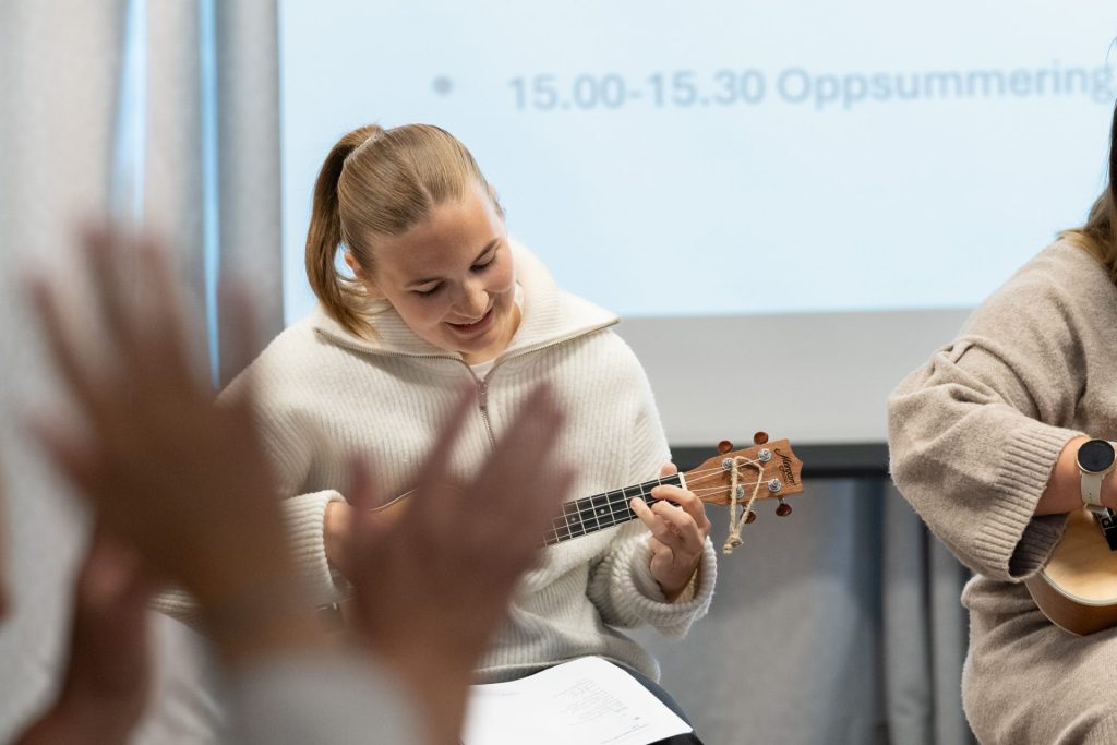 En kvinne spiller ukulele.