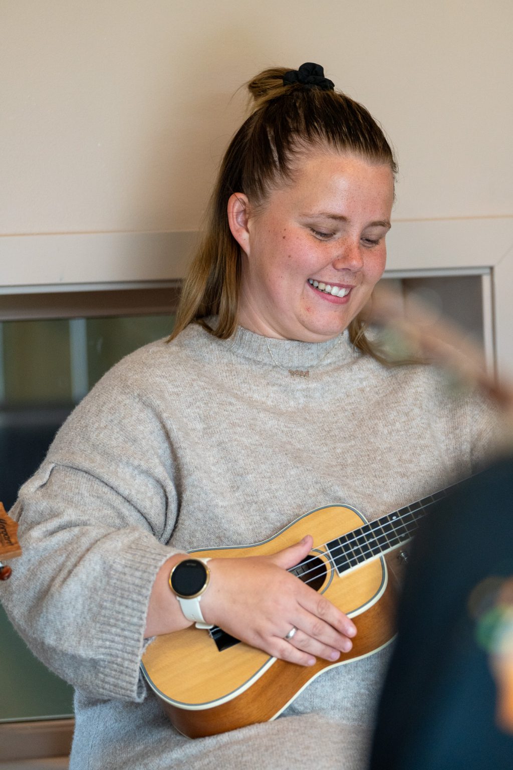 En kvinne spiller ukulele.