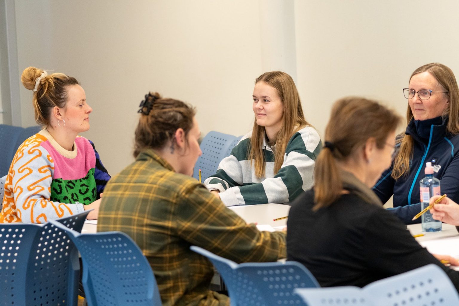 Studenter sitter sammen ved et bord.