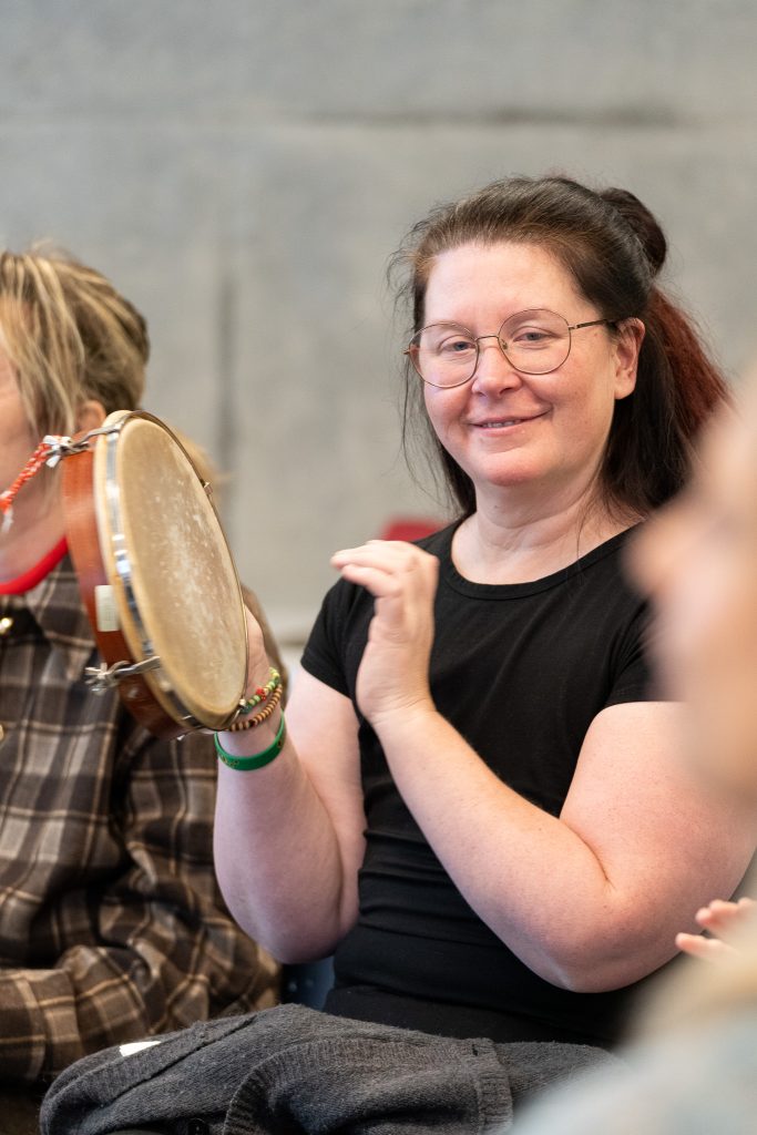 En kvinner spiller på en tromme.