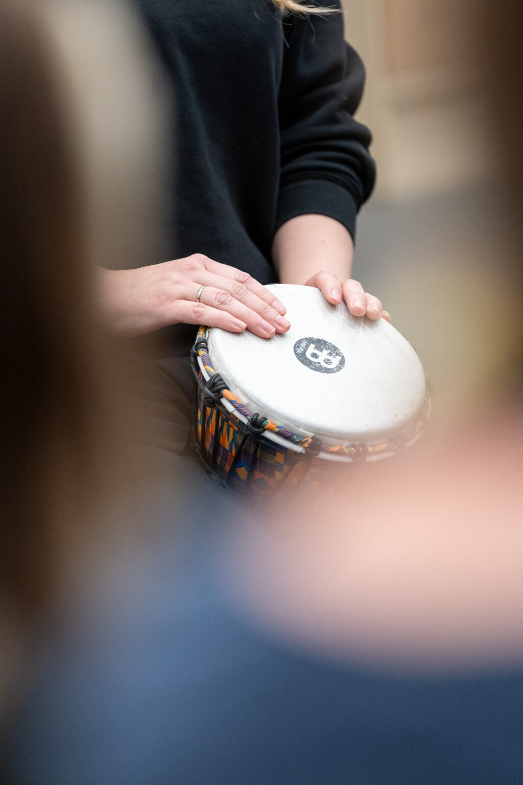 Et par hender holder en tromme.