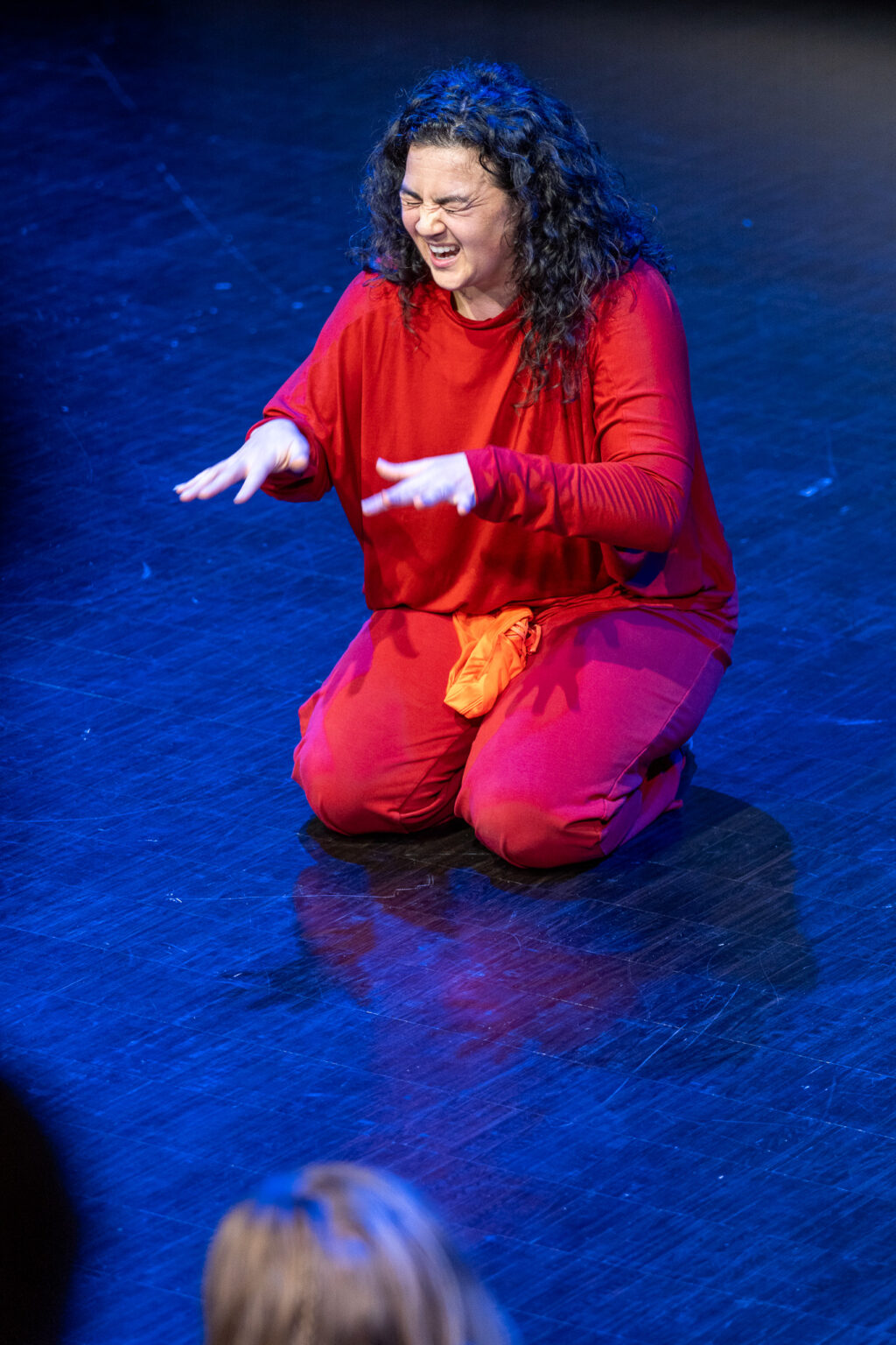 Nina Wollny sitter på scenen.