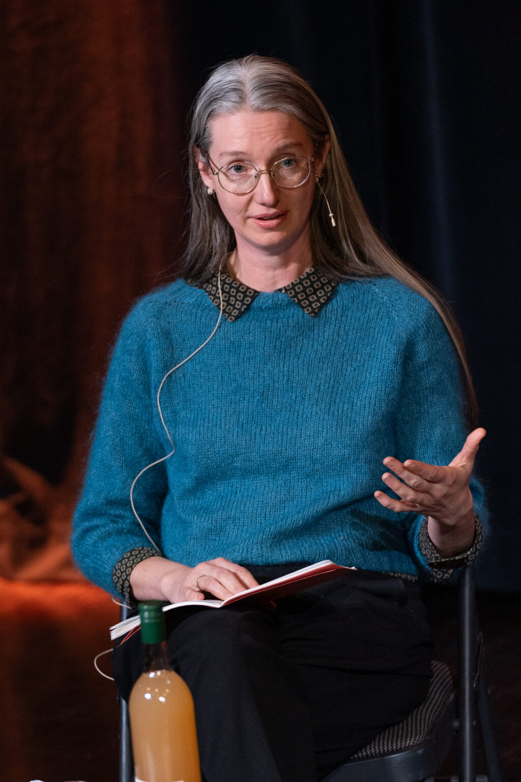 Liv Bjørnhaug Johansen leser bok på scenen.