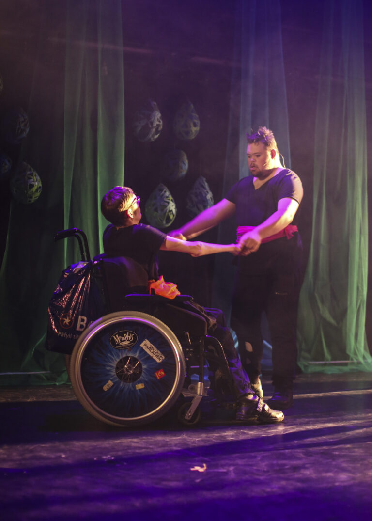 En person i rullestol danser med en annen person.